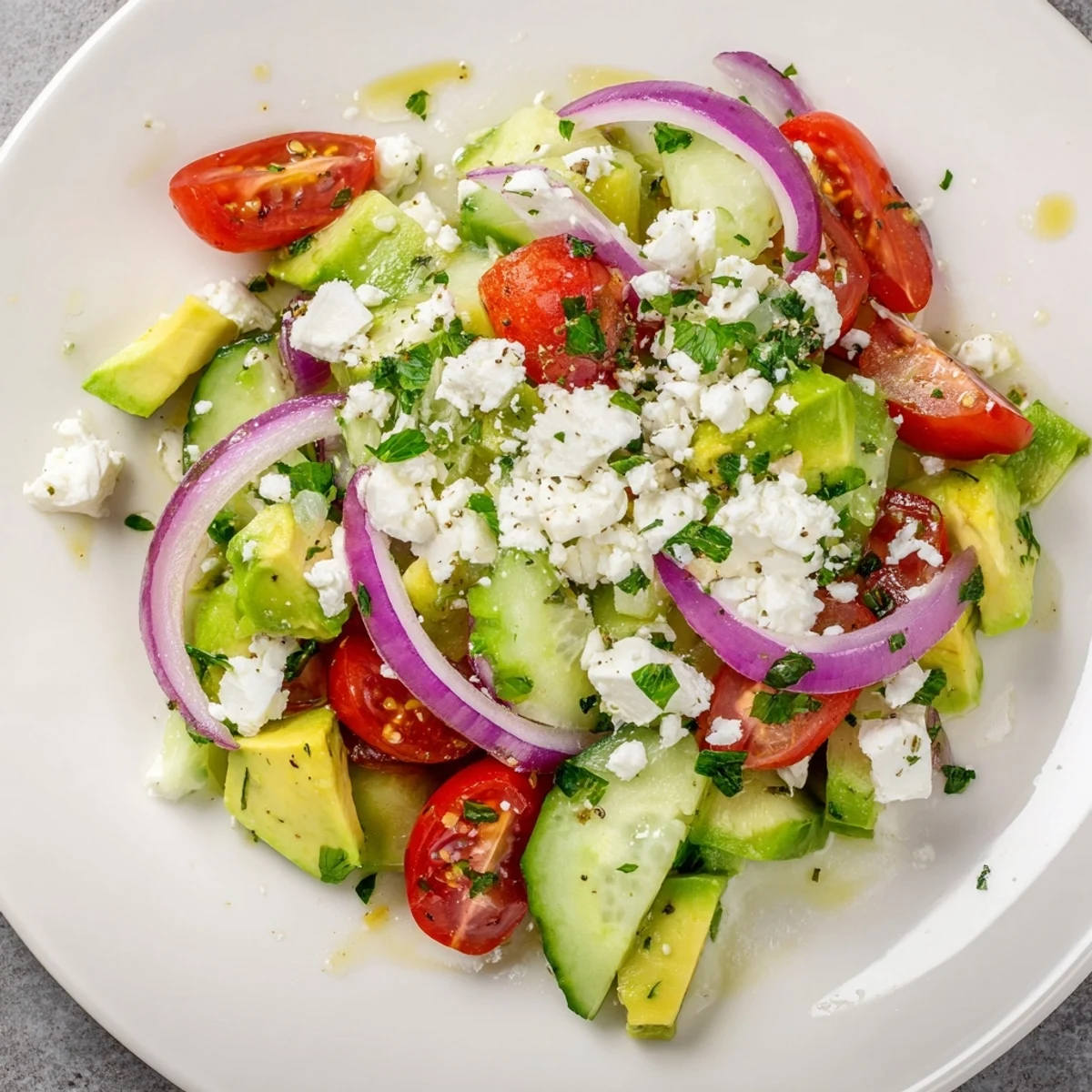 A refreshing bowl of Fresh Salad boasts juicy tomatoes, crisp cucumbers, and crumbled feta, perfect side.