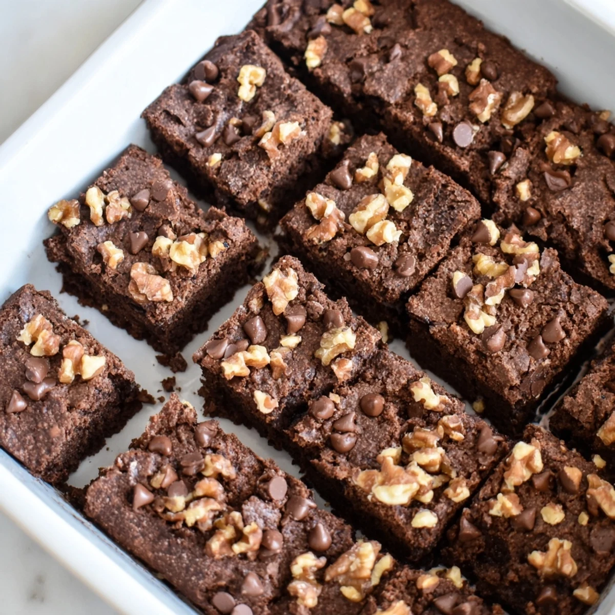 A freshly baked pan of rich Fudgy Walnut Brownies, ready to be cut and served warm with ice cream.