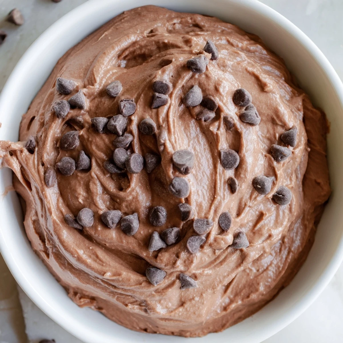 Creamy Brownie Batter Dip, swirled and ready to enjoy with fresh fruit and gluten-free cookies.