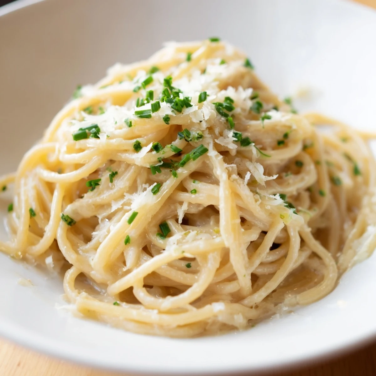 Steaming, golden-brown miso butter pasta, ready to be devoured with fresh chives and Parmesan.