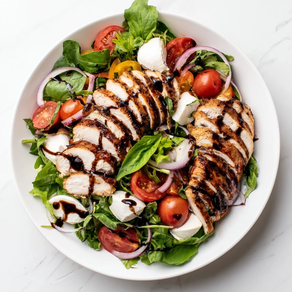 Grilled Caprese Chicken Salad with juicy chicken, ripe tomatoes, and fresh mozzarella ready to eat.