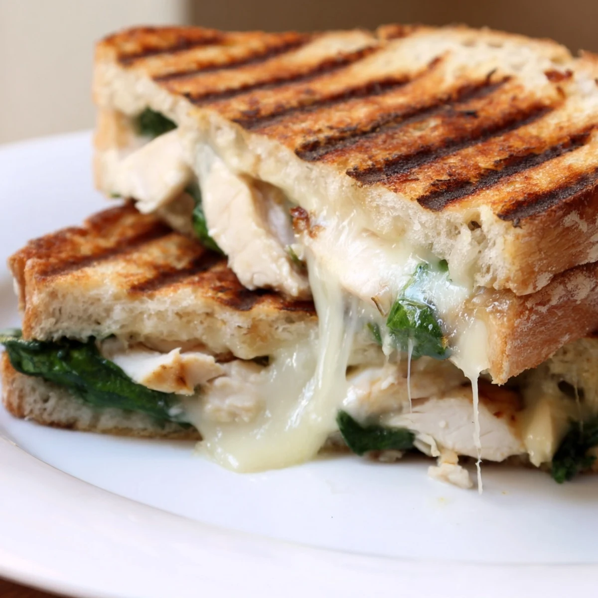 A warm, savory Grilled Chicken Spinach Panini pressed to golden perfection, served hot and gooey.  