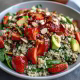 Refreshing strawberry avocado quinoa salad with fresh basil, toasted almonds, and tangy lemon-honey dressing for a healthy lunch.