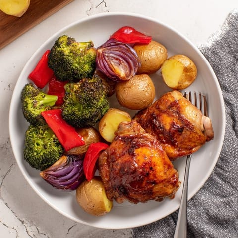 Golden honey lemon roasted chicken sheet pan atop broiled vegetables, ready for serving.