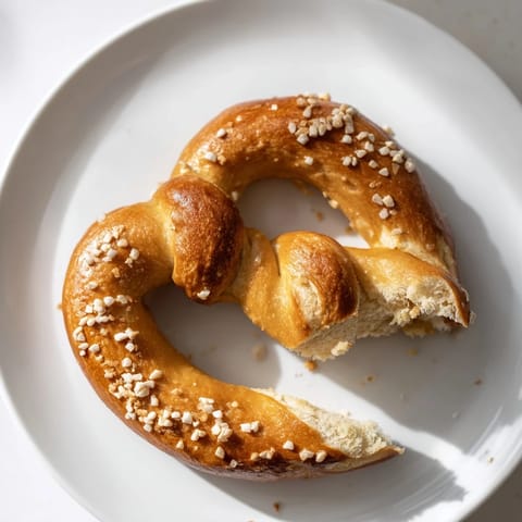 Freshly baked soft pretzels with a glossy crust and sprinkled with coarse sea salt.
