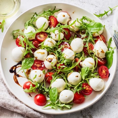 Bright, Italian-inspired The Pearly Strand salad showcasing basil, arugula, and a stunning strand of cheese.