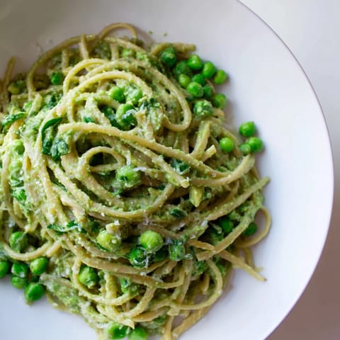 Bright green green goddess pasta, ready to enjoy, with visible herbs and a creamy texture.