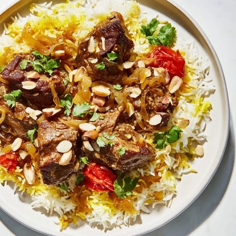 A steaming bowl of Qatari Majboos, with almonds and cilantro garnishing the fragrant lamb.