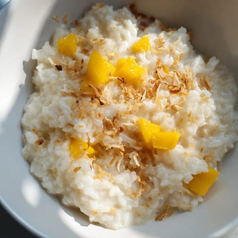 Creamy Coconut Rice Sweet dessert served in a white ceramic bowl with a spoon.  