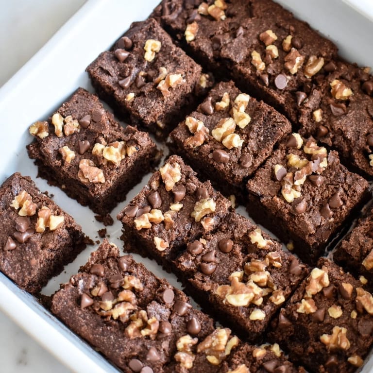 A freshly baked pan of rich Fudgy Walnut Brownies, ready to be cut and served warm with ice cream.