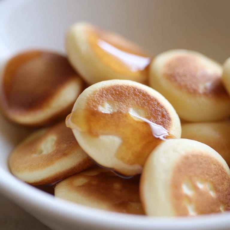 A bowl overflowing with delightful, bite-sized fluffy pancake cereal, perfect for a cozy brunch.