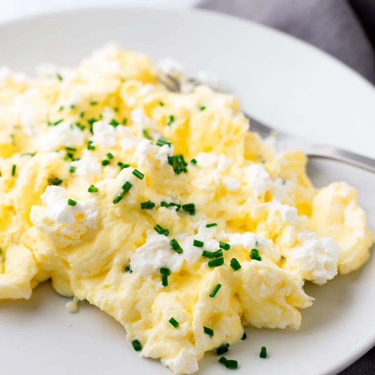 A plate of Cottage Cheese Scrambled Eggs, garnished with herbs, ready to serve and enjoy.