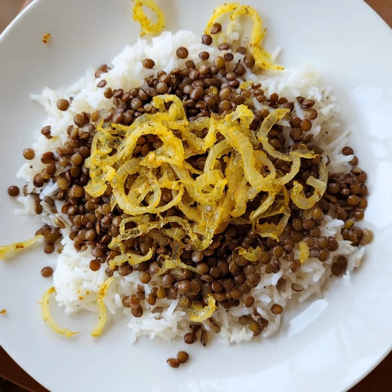 View a close-up of the flavorful Lebanese Mjadra, showcasing perfectly cooked lentils and rice alongside crispy onions.