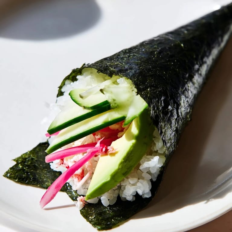 Freshly prepared sushi rice hand rolls served with pickled ginger, wasabi, and soy sauce on the side.