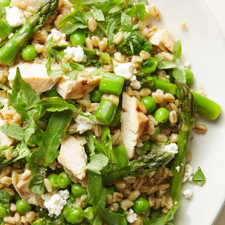 Enjoy this wholesome Warm Spring Farro Chicken Salad as a light lunch or dinner, garnished with fresh herbs and optional crumbled feta for a creamy tang.