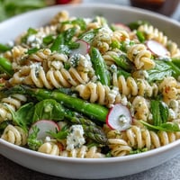 Bright spring pasta salad with lemon vinaigrette and crisp radishes, bursting with fresh seasonal vegetables and tangy citrus dressing.